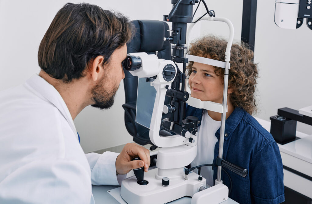 An optometrist performing a slit-lamp exam on a child