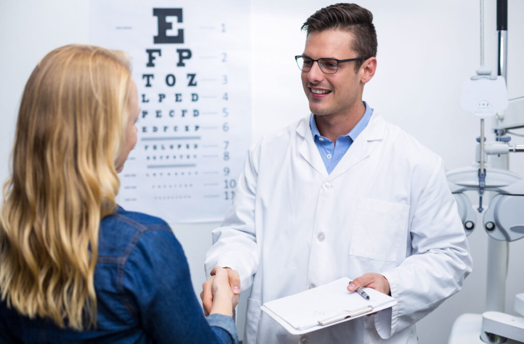 A patient and optometrist shake hands in an optometry clinic.
